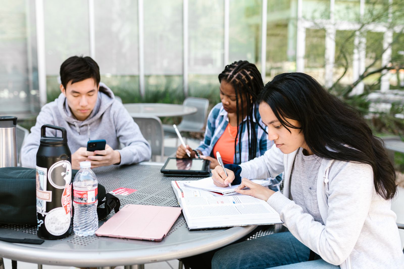 University students sharing ideas and studying together outdoors